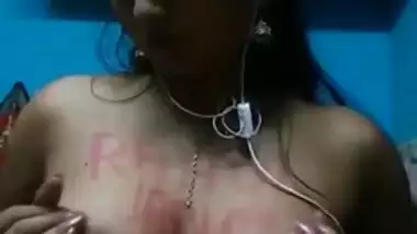 Indian girl with headphones in ears exposes XXX boobies with sex text on